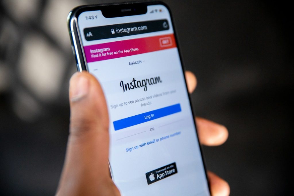 Smartfon z aplikacją Instagram w dłoni – zasięgi na Instagramie